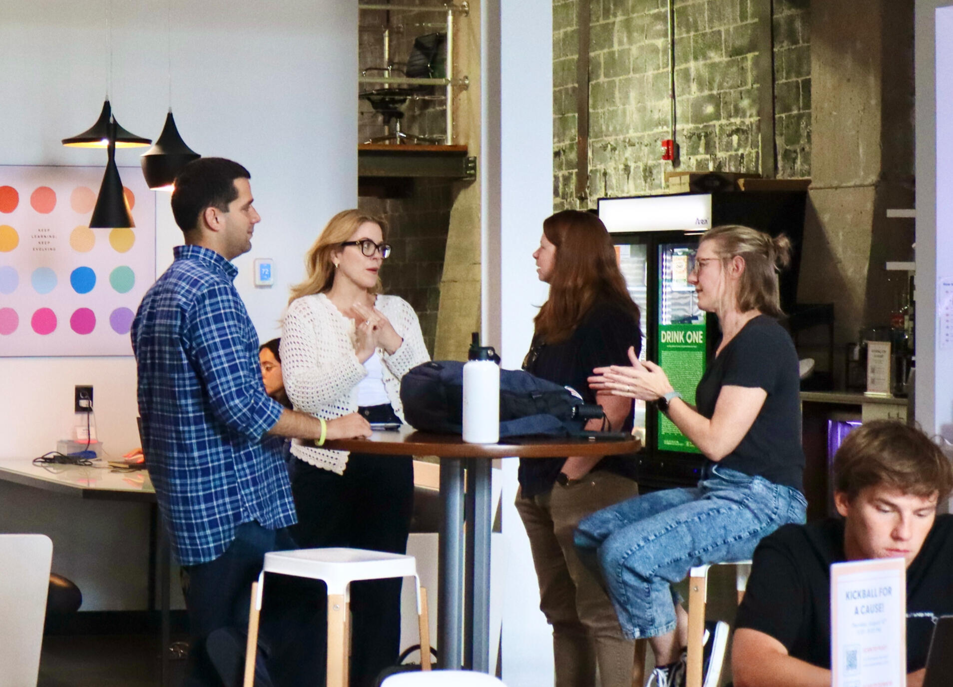 four people gathered around a table talking